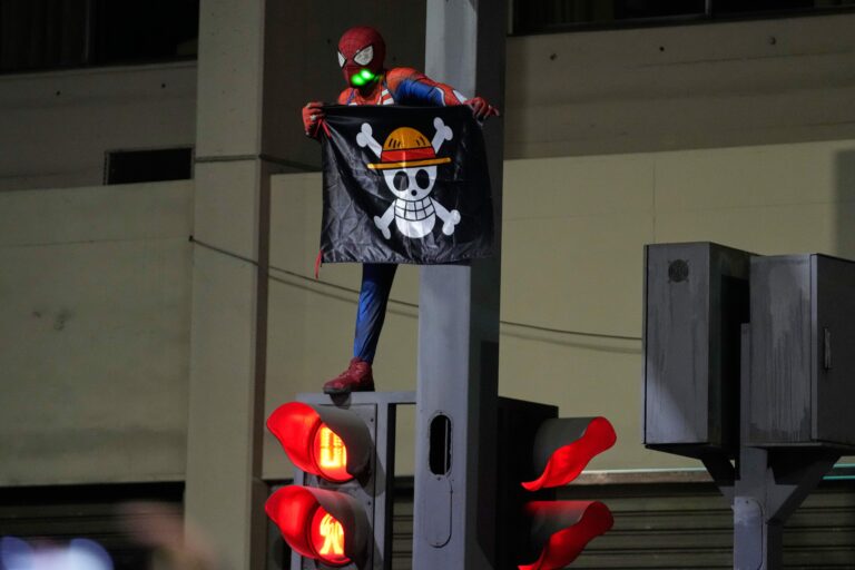 demonštrant Spiderman vlajka semafór