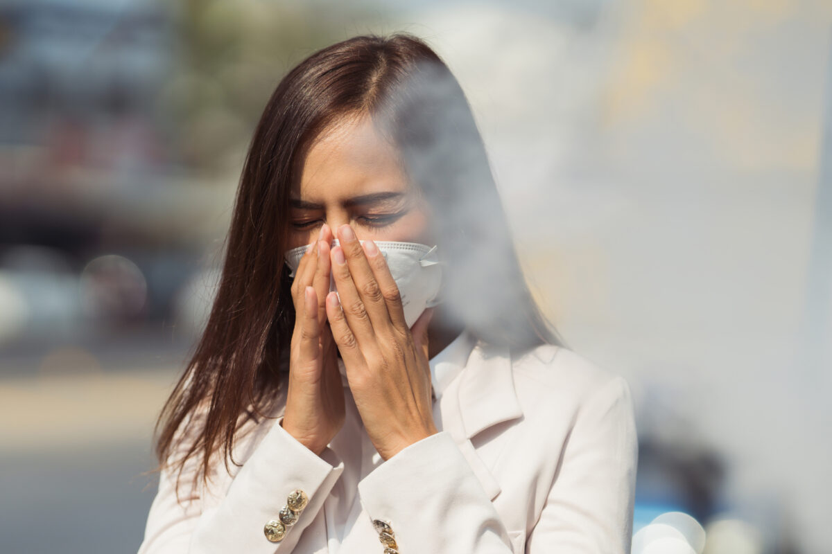 Asian woman are going to work.she wears N95 mask.prevent PM2.5 dust and smog.she is coughing