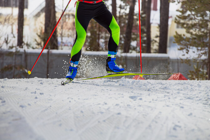 Skier athlete running uphill on cross country skiing