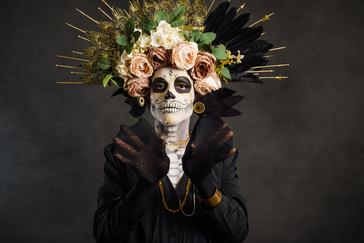 Studio portrait of Drag Queen catrin. Catrin dressed in black with flower crown. Makeup for halloween or day of the dead.
