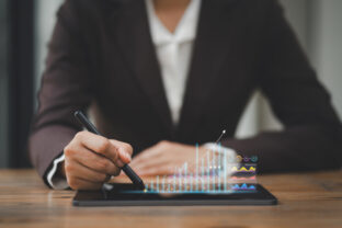 Business professional analyzing financial trends on digital tablet at office desk