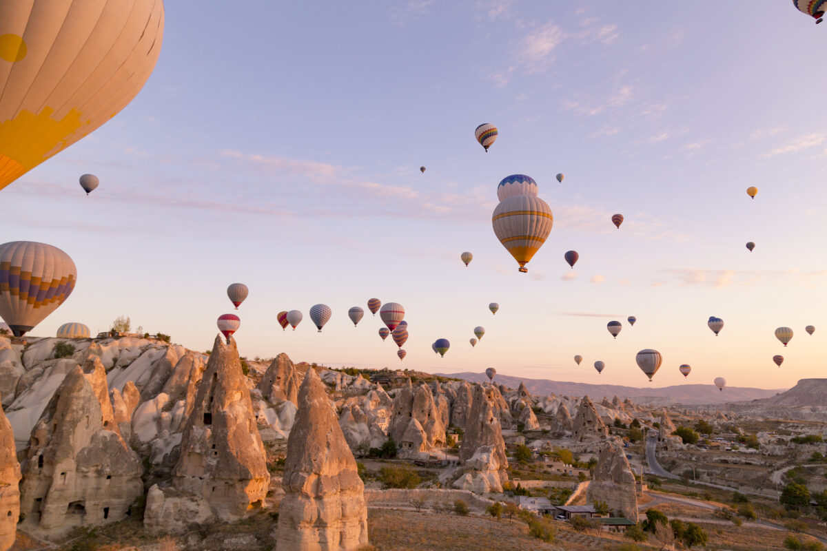 Hot Air Balloons Flying Over Rocks Against Sky