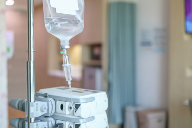 Close up medical intravenous IV drip in hospital background
