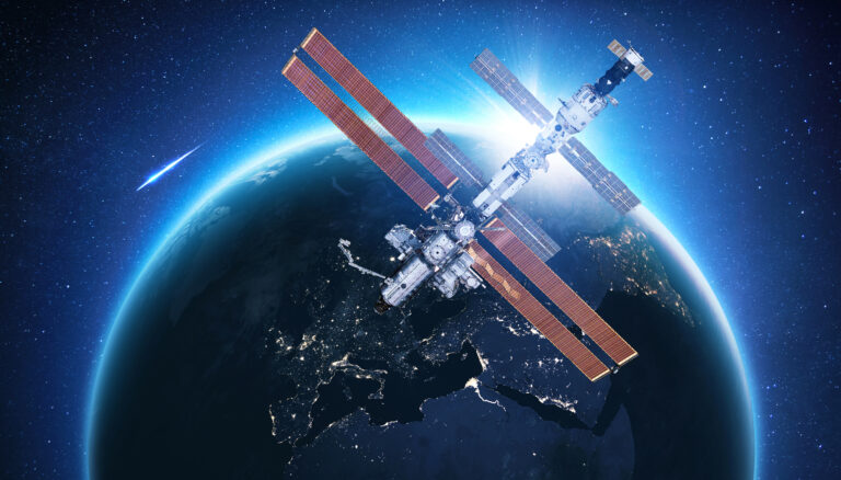 The ISS flies near blue night planet Earth at sunset. Space mission and space exploration. Communications and technologies in Earth orbit