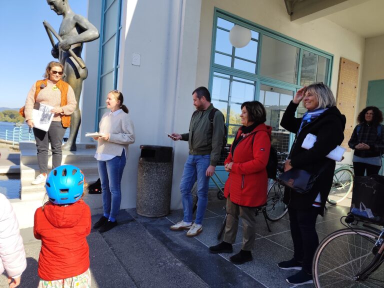 Architektky Eva Rohoňová a Lívia Gažová vítajú účastníkov Dňa architektúry 2025 pri soche Barlolámača v Piešťanoch. Cykloprehliadka predstavila ženský pohľad na architektúru mesta.