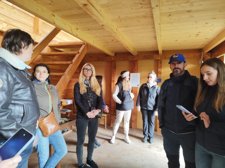 Skupina návštevníkov a organizátorov v Turistickej útulni Zlatno počas otvorenia Tajomného chodníka Tribečom