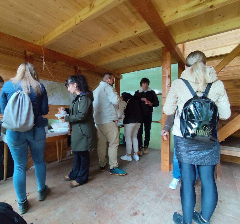 Skupina návštevníkov a organizátorov v Turistickej útulni Zlatno počas otvorenia Tajomného chodníka Tribečom