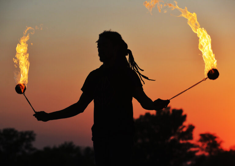 Ohnivý tanečník Nick May západ slnka silueta