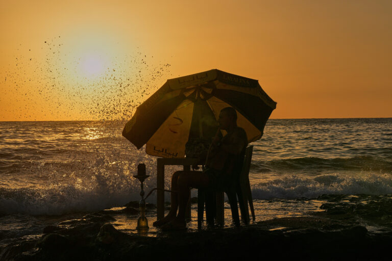 muž fajčenie vodná fajka shisha západ slnka pláž Sýria