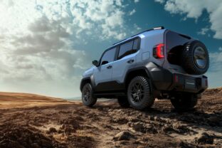 A white jeep is parked on a dirt road. The jeep has a large carg