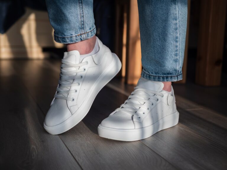Closeup shot of a woman showing her white shoes in the room