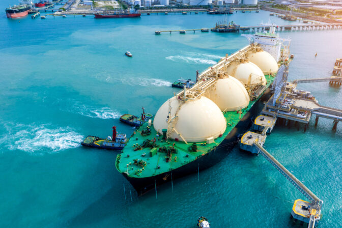 LNG (Liquefied natural gas) tanker anchored in Gas terminal gas tanks for storage. Oil Crude Gas Tanker Ship. LPG at Tanker Bay Petroleum Chemical or Methane freighter export import transportation