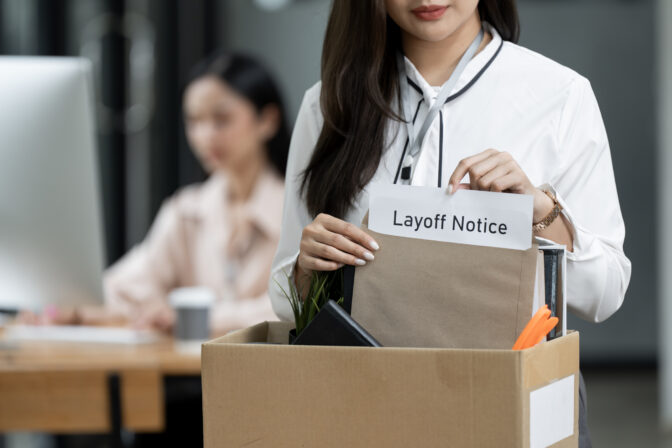 Closeup woman holding brown paper envelope in a Cardboard box  standing in office.