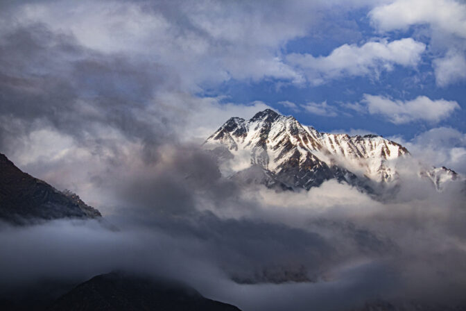 Himalayan mountain range under partial cloud cover.