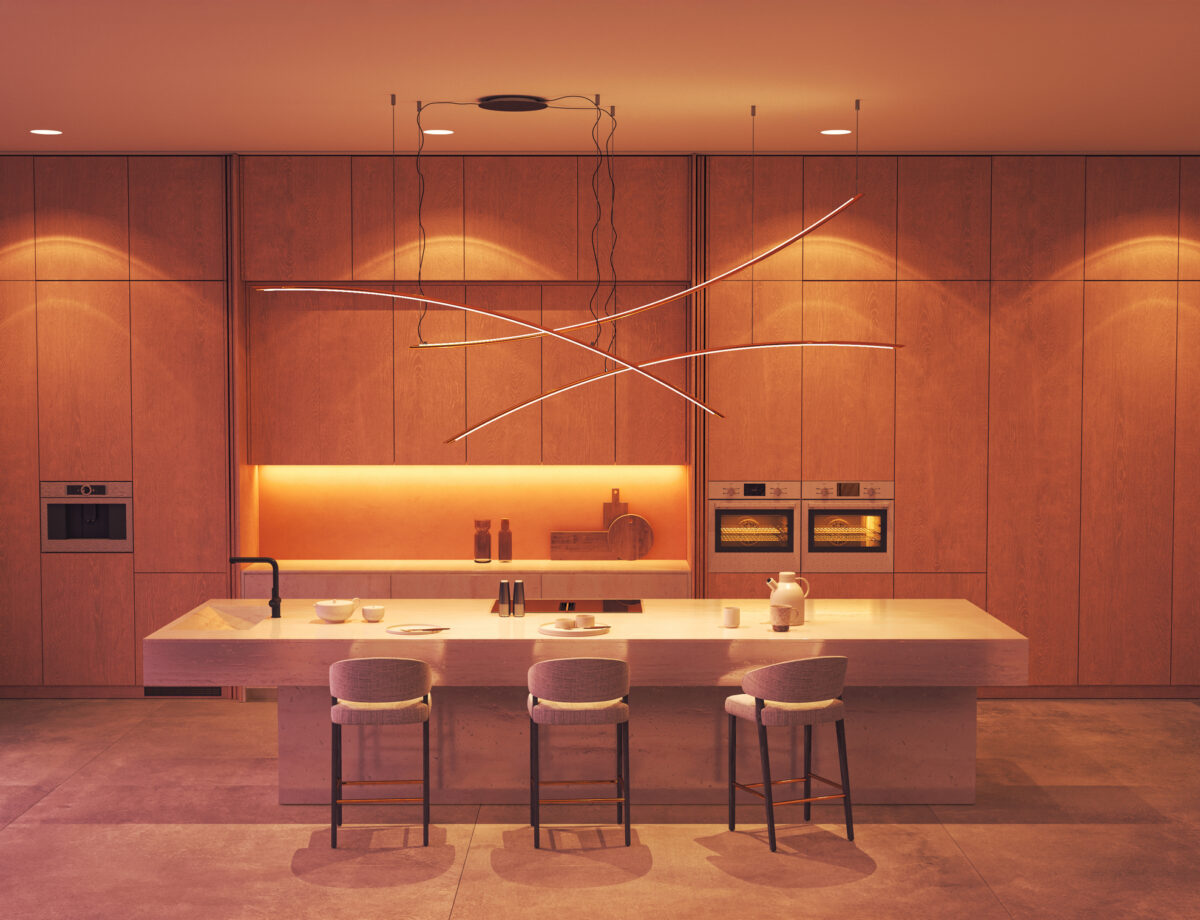 Minimalist luxury kitchen with sculptural lighting and warm wood cabinetry