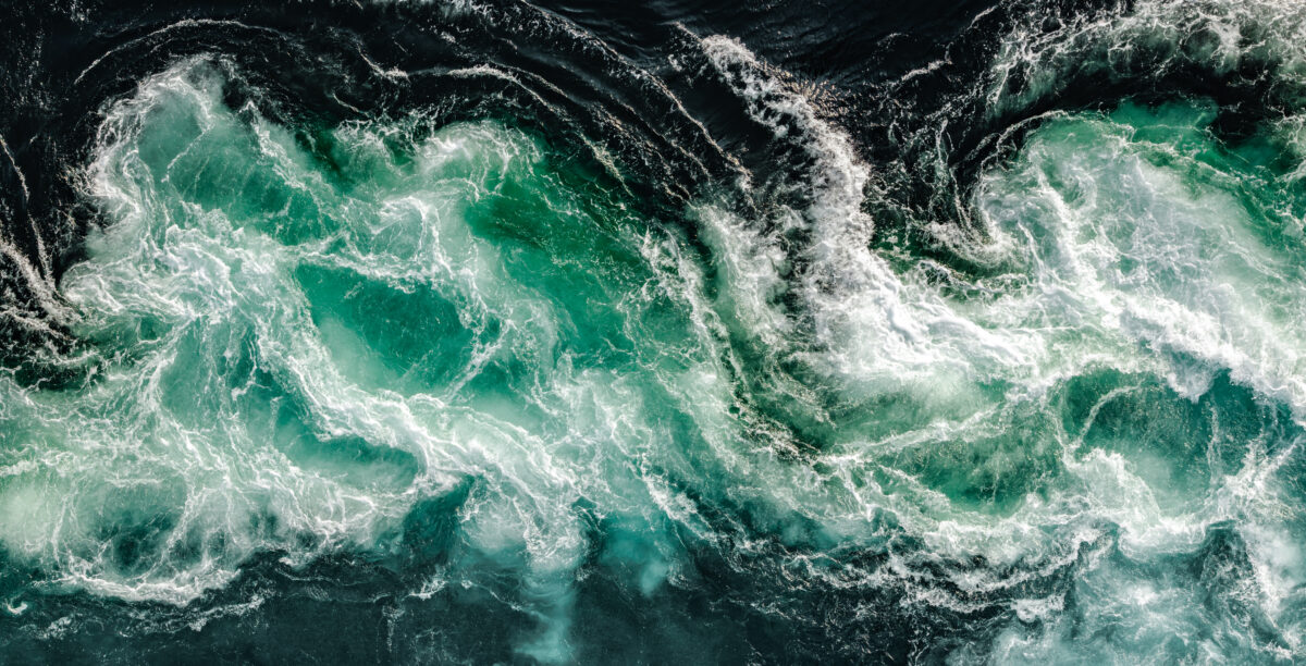 Blue waves of water of the river and the sea meet each other during high tide and low tide.