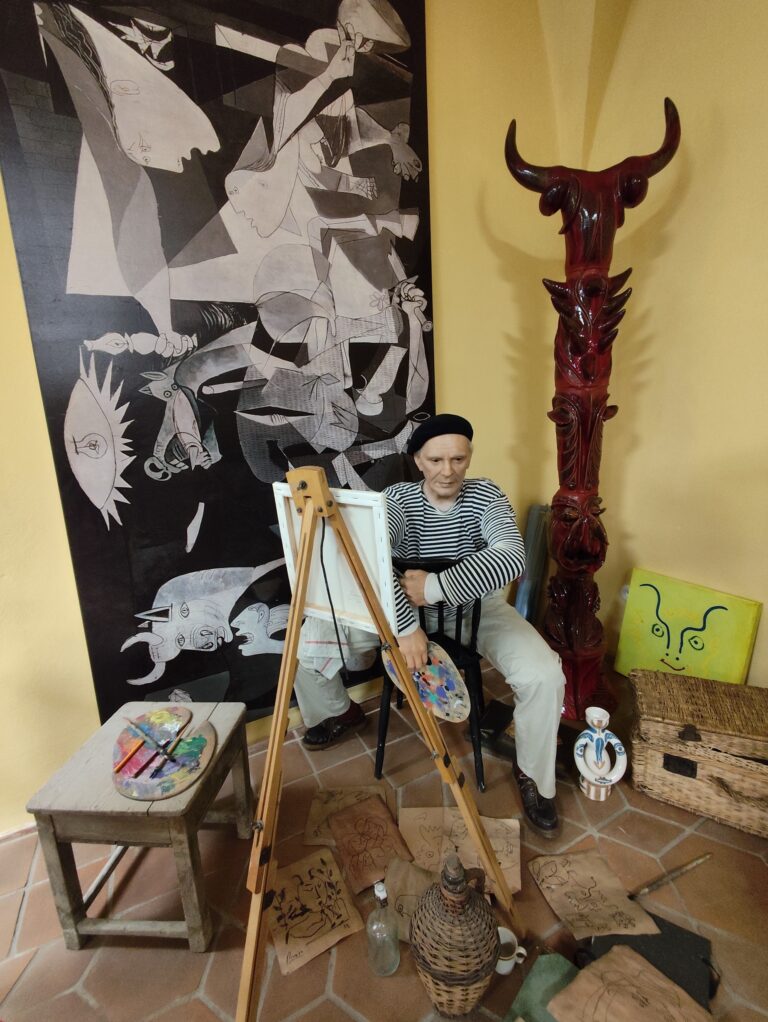 Realistická inštalácia predstavuje Pabla Picassa v ateliéri obklopeného skicami, farbami a plátnom.