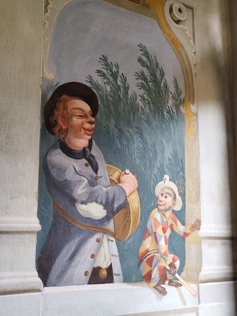 Maškarný sál s freskami Josefa Lederera, zobrazujúcimi postavy v maskách.