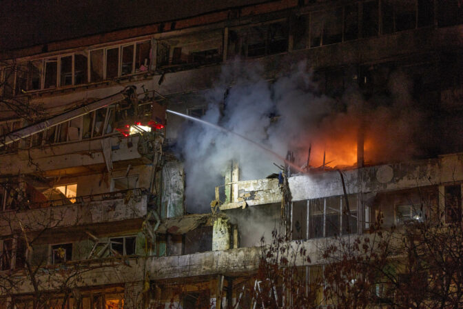 Firefighters put out the fire after a drone hit a multi-storey residential building