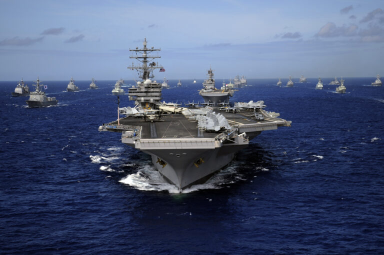 Aircraft carrier USS Ronald Reagan leads a mass formation of ships through the Pacific Ocean.