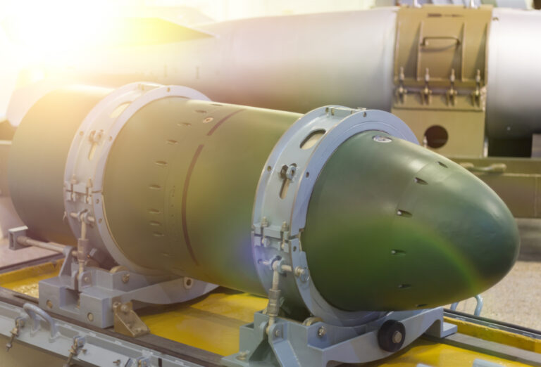 A warhead on a transport stand, against a rocket.