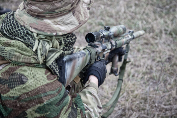 Kneeling commando army soldier marksman over shoulder view