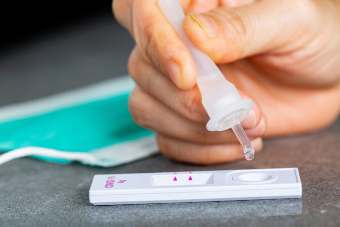 Drop nasal sample into rapid antigen test stick.