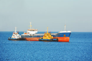 Tugboat assisting bulk cargo ship