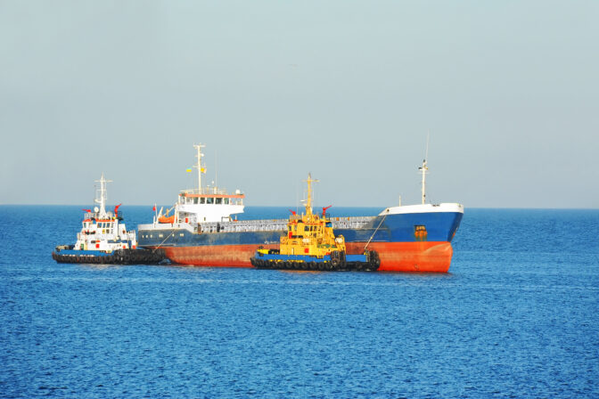 Tugboat assisting bulk cargo ship