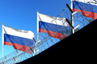 The Russian flag hangs in the cloudy sky outside the prison's barbed wire. waving in the sky