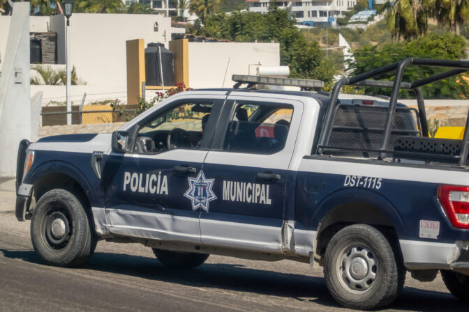 A municipal police truck from Los Cabos with the designation DST 1115 patrols a residential area.