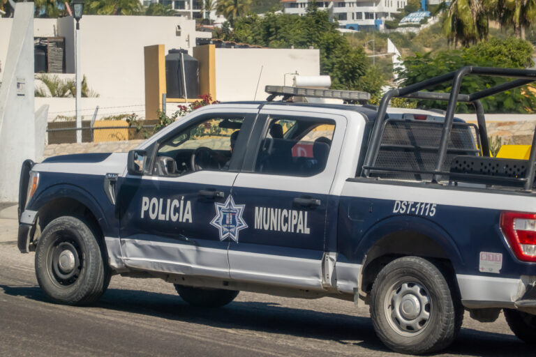 A municipal police truck from Los Cabos with the designation DST 1115 patrols a residential area.