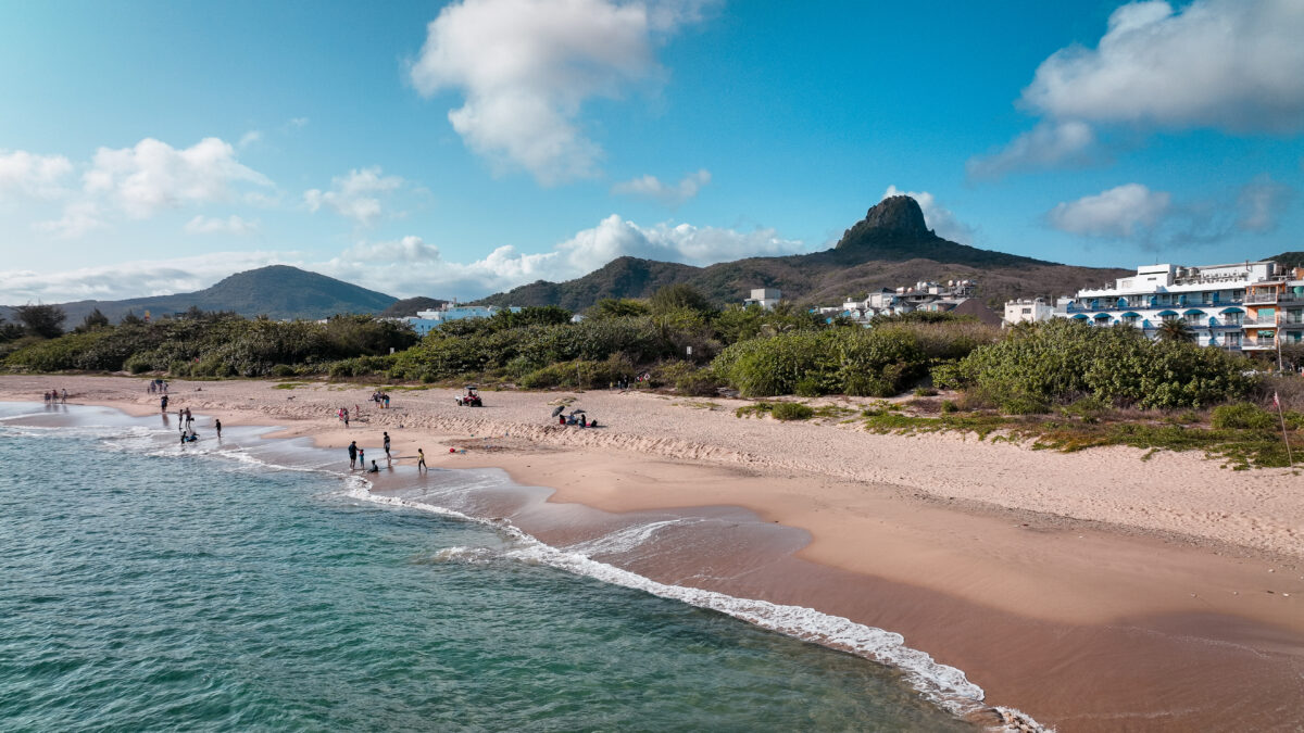 Relaxing beach day at Kenting Baishawan in Taiwan with scenic mountains and blue skies