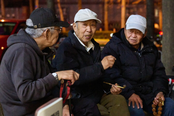 Elderly men talking on a bench in Beijing, April 2025