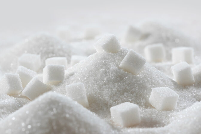 White granulated sugar and refined sugar cubes close up in the kitchen