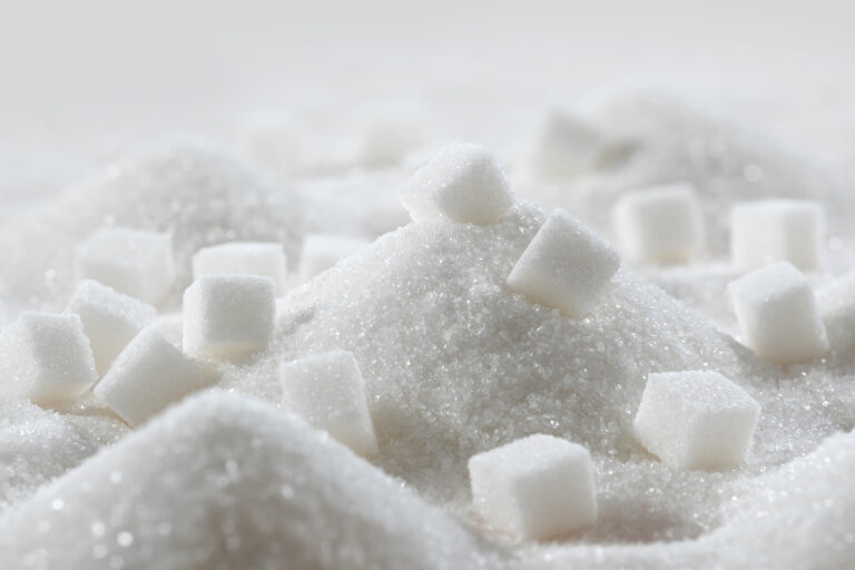 White granulated sugar and refined sugar cubes close up in the kitchen