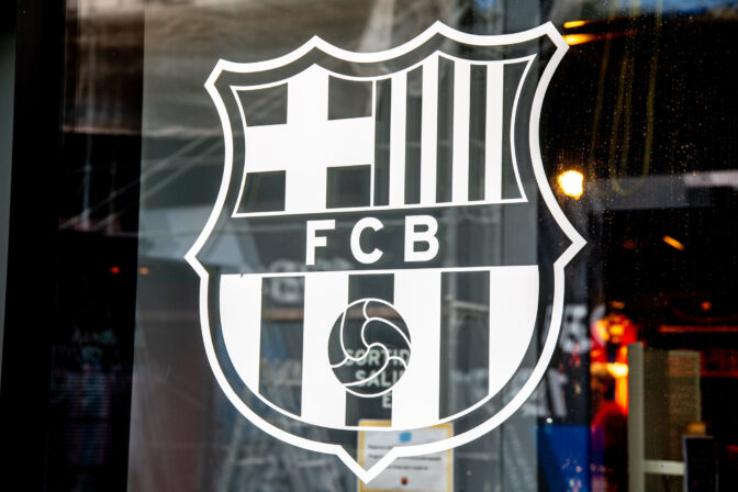 Translucent FC Barcelona logo on a pane showcases contrast with the dark interior