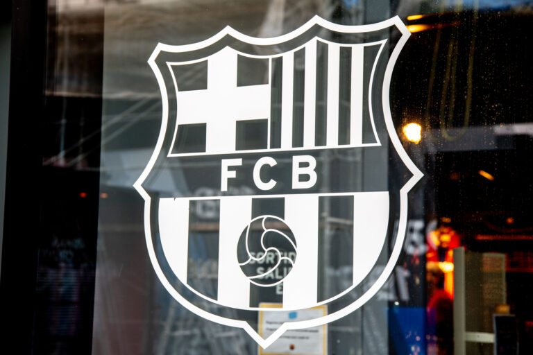 Translucent FC Barcelona logo on a pane showcases contrast with the dark interior