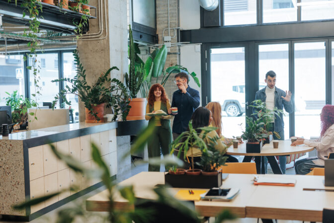 Coworkers discussing business strategy in modern green office