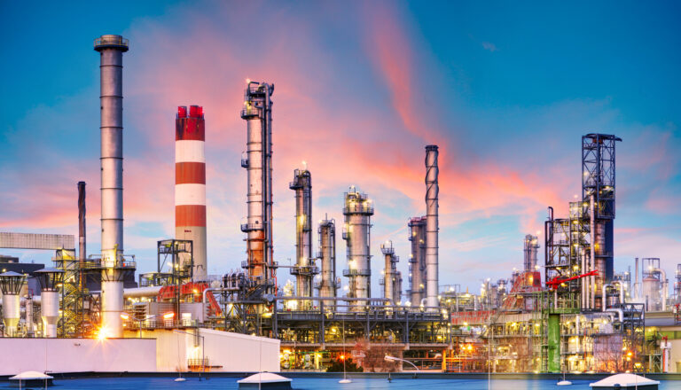 Oil refinery and plant and tower column of Petrochemistry industry in oil and gas industrial with cloud orange sky the sunrise background