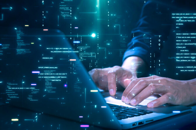 Close up of hands typing on a laptop with glowing programming code and binary graphics, symbolizing cybersecurity technology coding or software development.