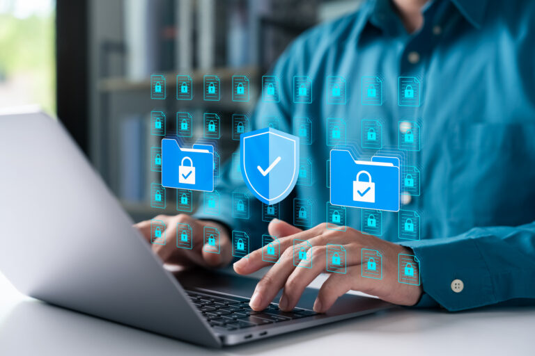 Cybersecurity concept with businessman using a laptop to protect data folders and digital files. Represents data privacy, secure information, and advanced cyber protection.