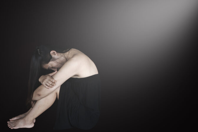 Stressful and hopeless woman sitting on ground