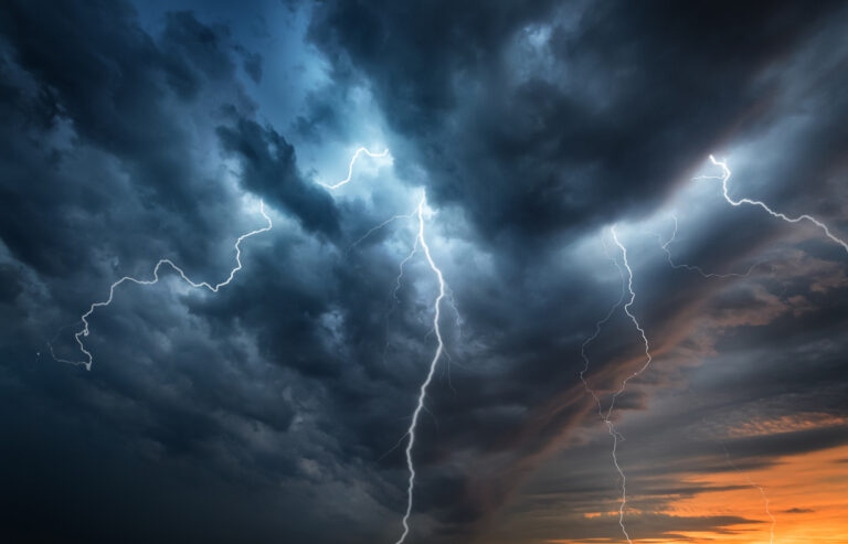Lightning thunderstorm flash over the night sky.