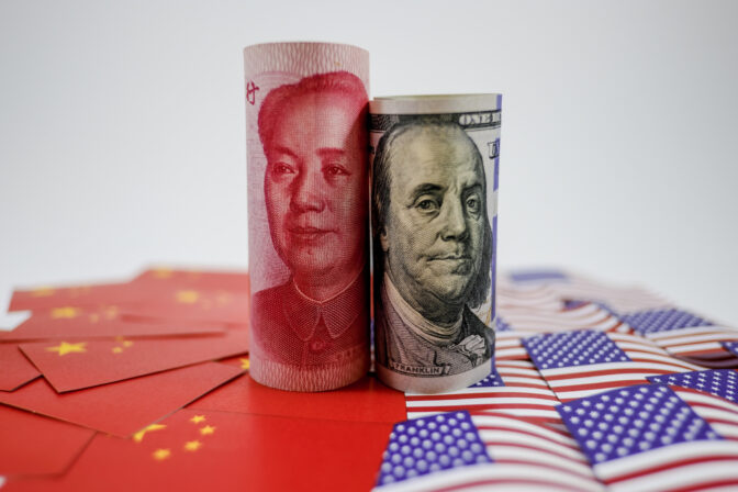 China yuan banknote on China flags and US dollar banknote on united states flags for trade war