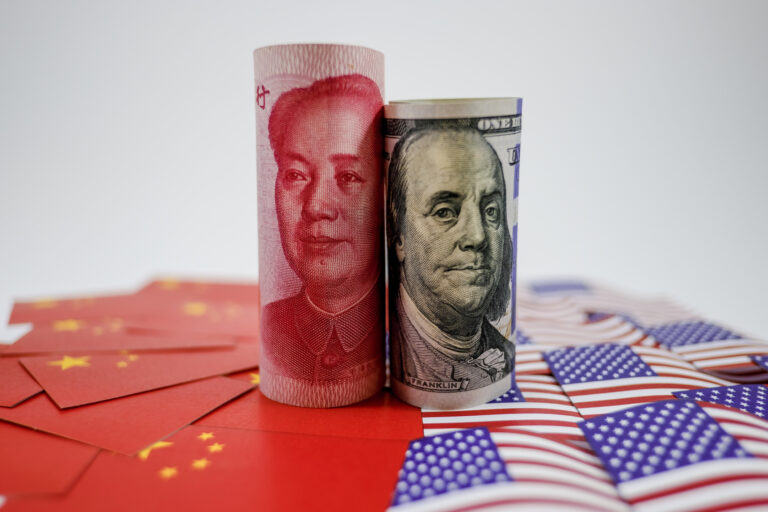 China yuan banknote on China flags and US dollar banknote on united states flags for trade war
