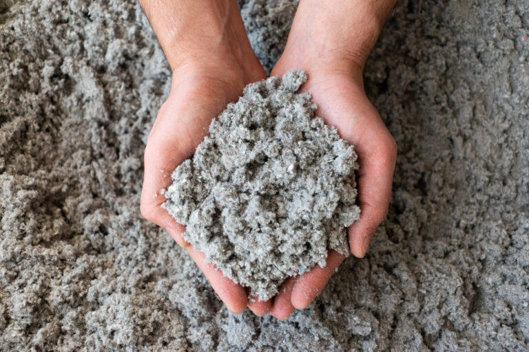 Close shot of eco friendly cellulose insulation filling held in hand