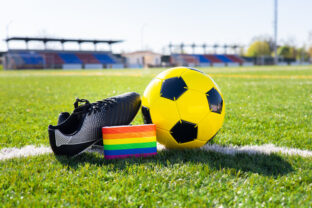 Rainbow colors of gay pride for fight for rights of LGBTQ collective in soccer and football field. Homosexuality and transsexuality in sport.