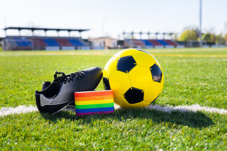 Rainbow colors of gay pride for fight for rights of LGBTQ collective in soccer and football field. Homosexuality and transsexuality in sport.