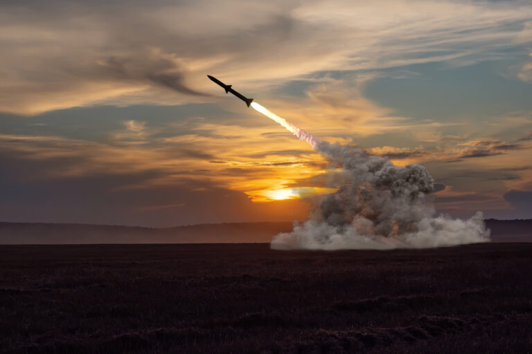 Rocket launch against the background of the evening field, the setting sun.
